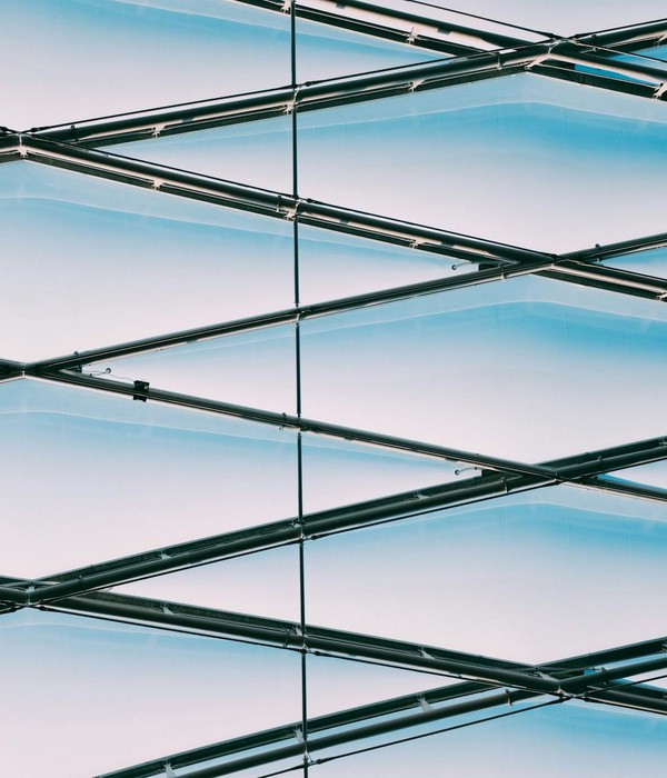 Low angle view of a modern geometric metal structure with a blue sky background.